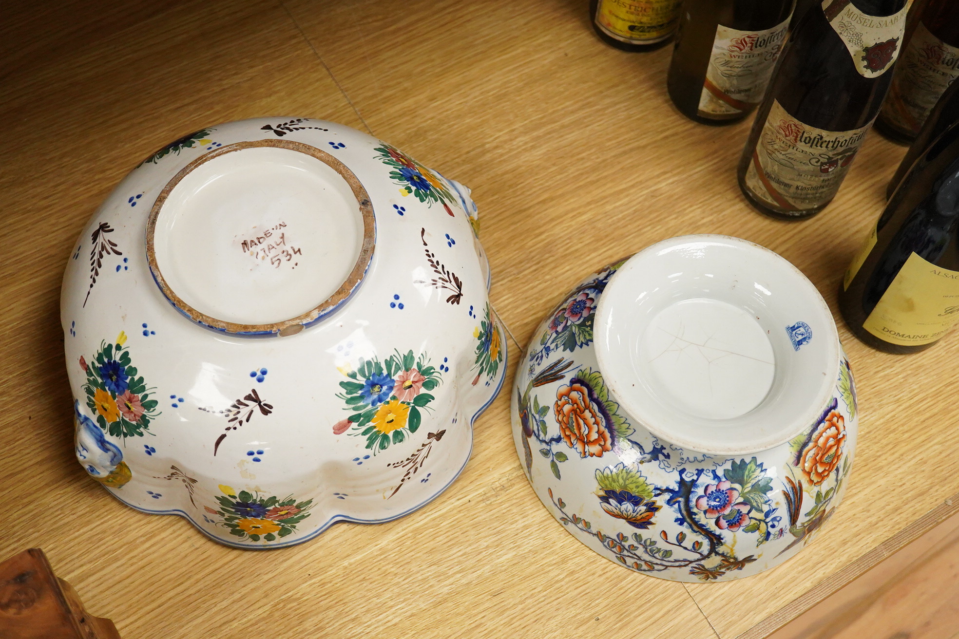 An Italian faience punch bowl painted with flowers and masks and an ironstone pedestal bowl, largest 31cm in diameter